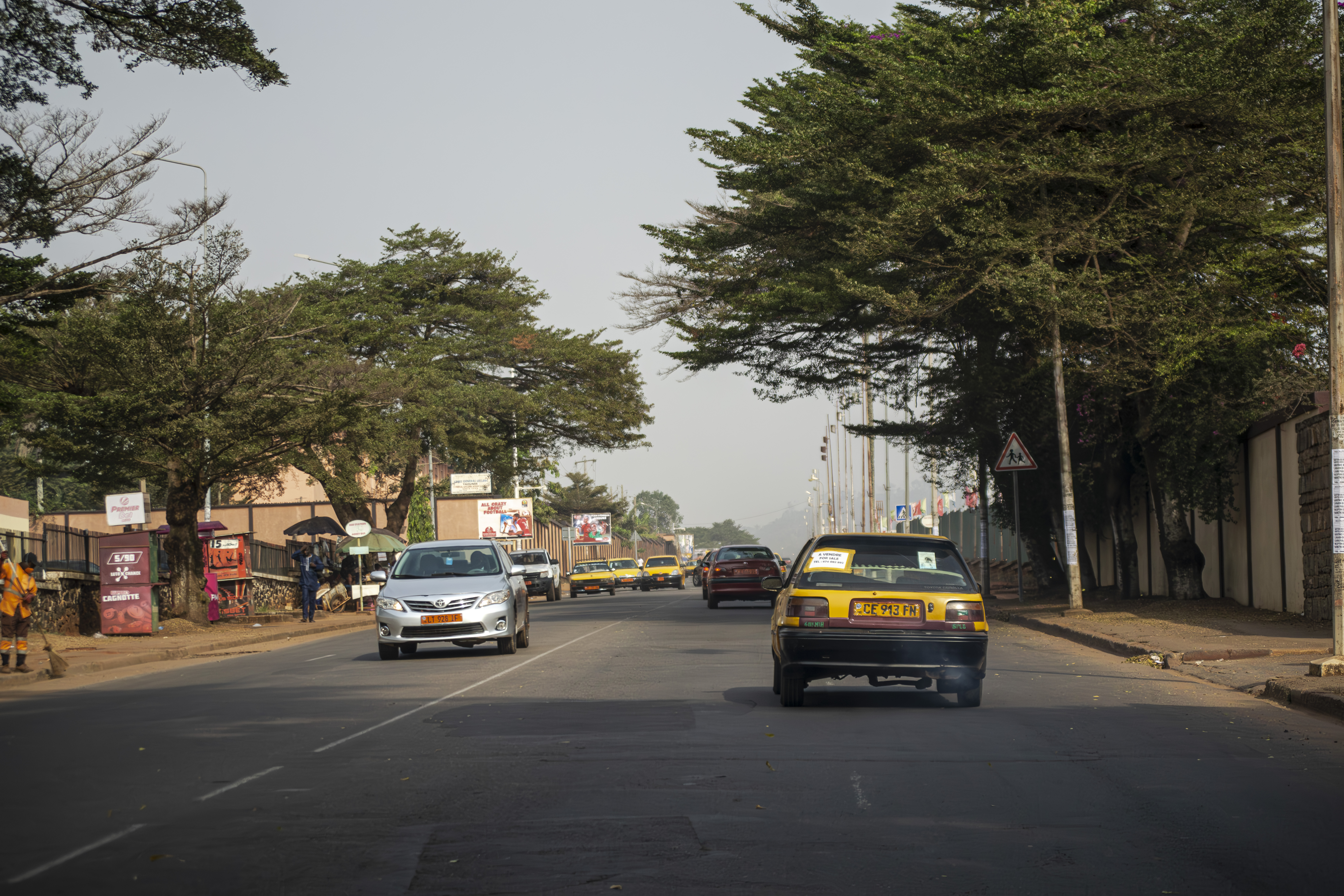 Trafic routier avec Taxis jaunes sur un rue near Lycee Leclerc à Yaounde, Cameroun.