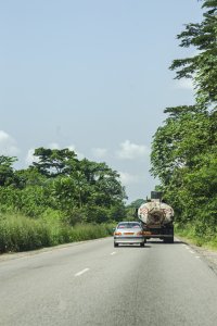 Berline roulant behind un camion-citerne sur un route déserte à Cameroun