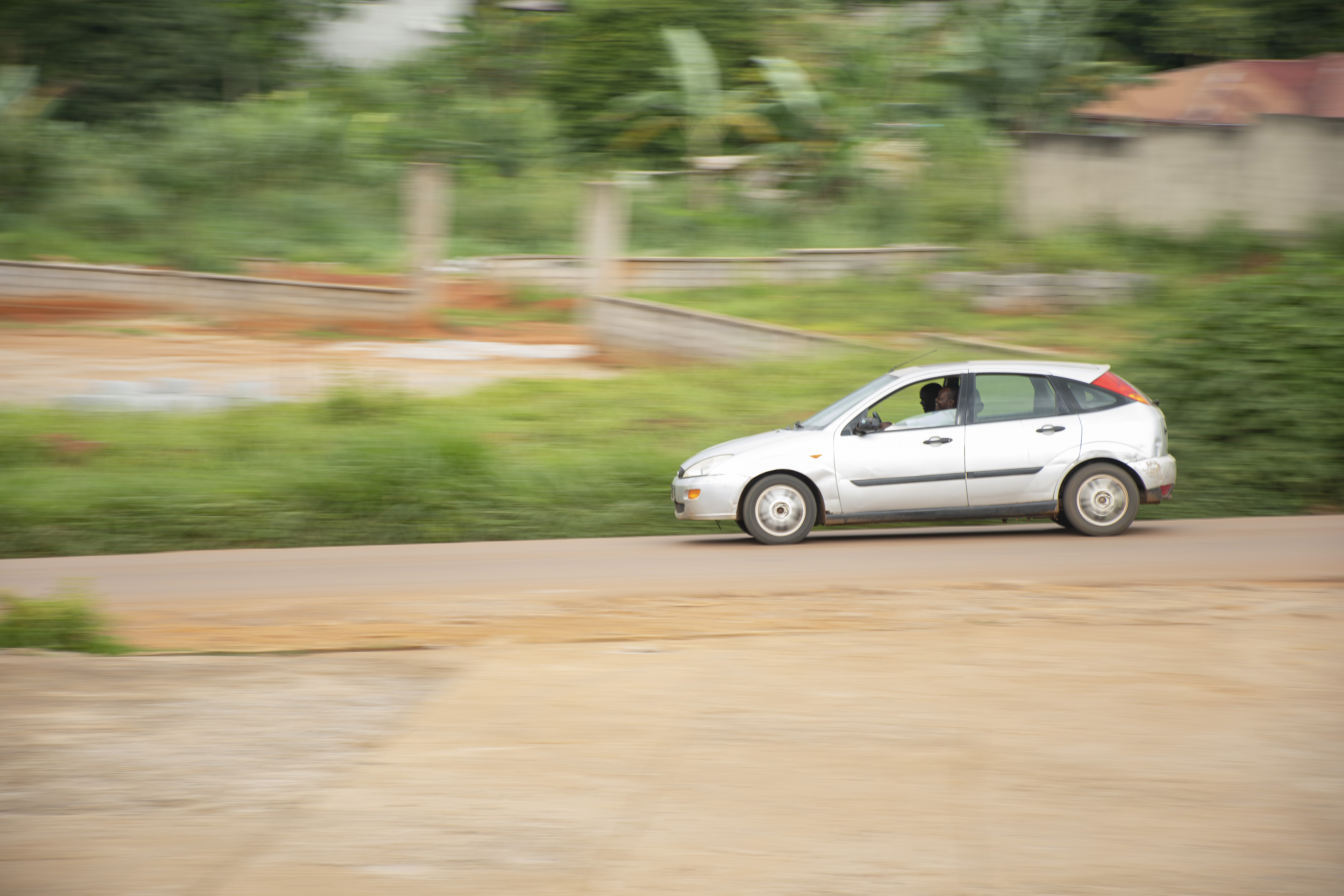 Petite berline filant à vive allure down un Yaounde rue