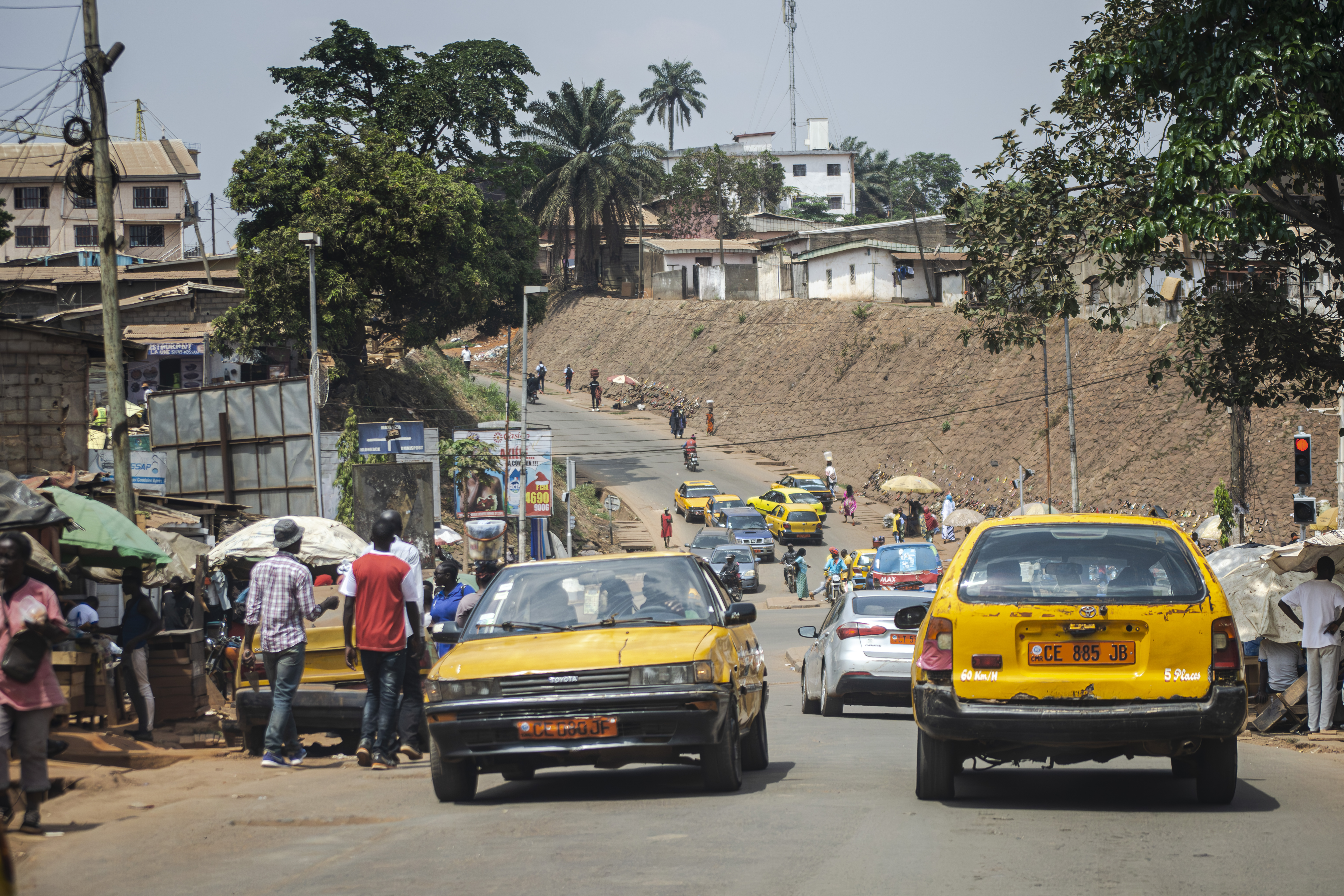 Circulation avec Taxis jaunes et pedestrians à Carrefour elig edzoa à Yaounde, Cameroun