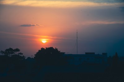 Beau coucher de soleil sous un ciel bleu avec silhouetted trees sur Abidjan