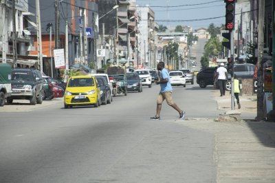 Homme traversant un rue à Abidjan, Côte d'Ivoire
