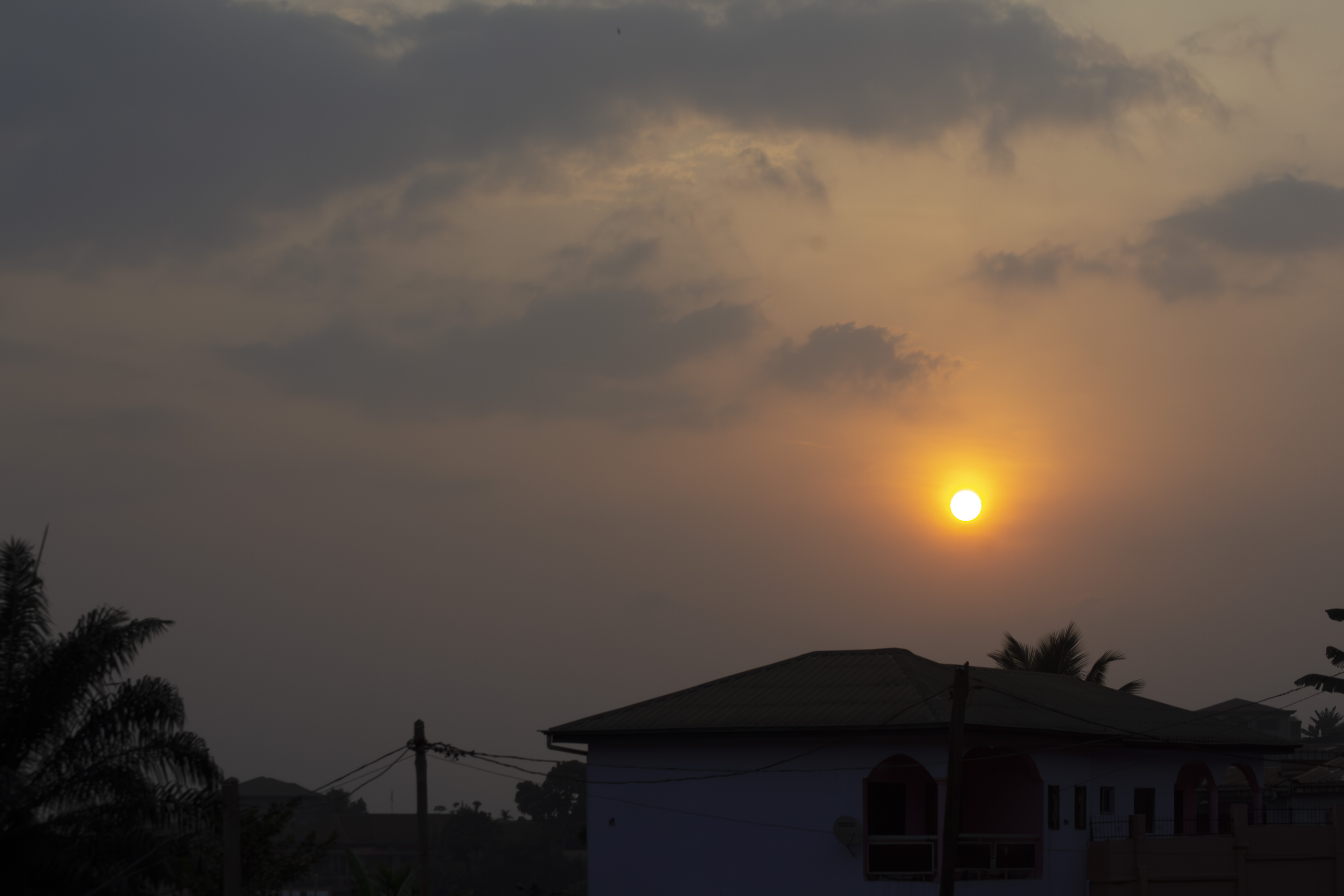 Coucher de soleil avec silhouettes de poteaux électriques, bâtiments et trees à Yaounde, Cameroun 01