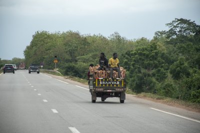 Tricycle avec passagers à le back roulant sur le autoroute à Côte d'Ivoire