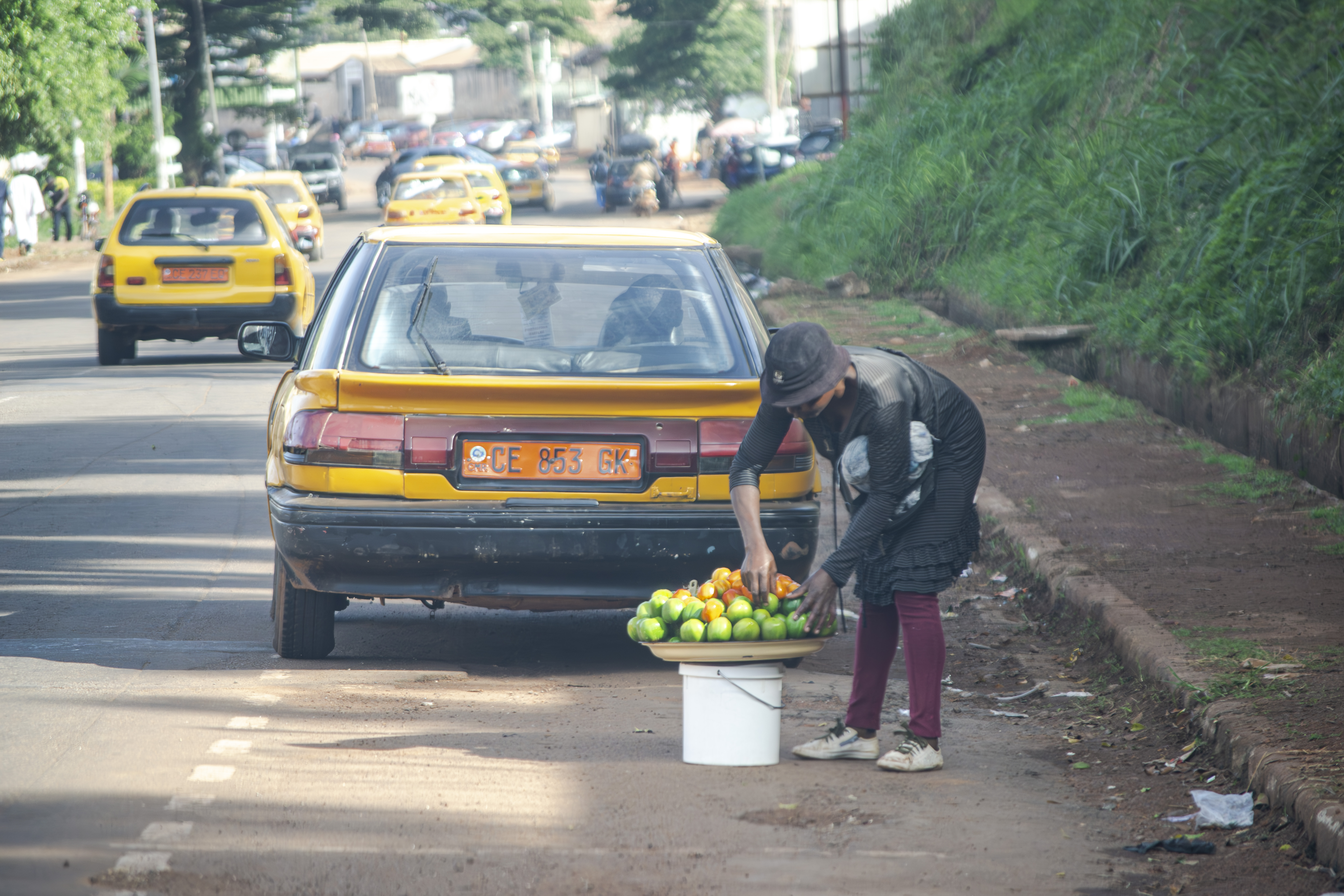 Vendeuse arrangeant her plateau à un Yaounde rue